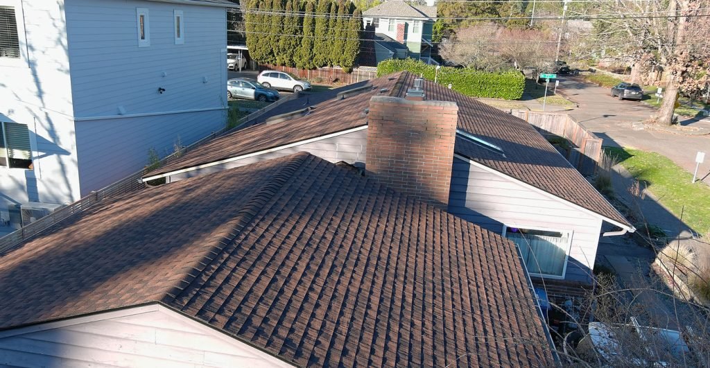 Newly installed asphalt shingle roof on residential home in suburban neighborhood