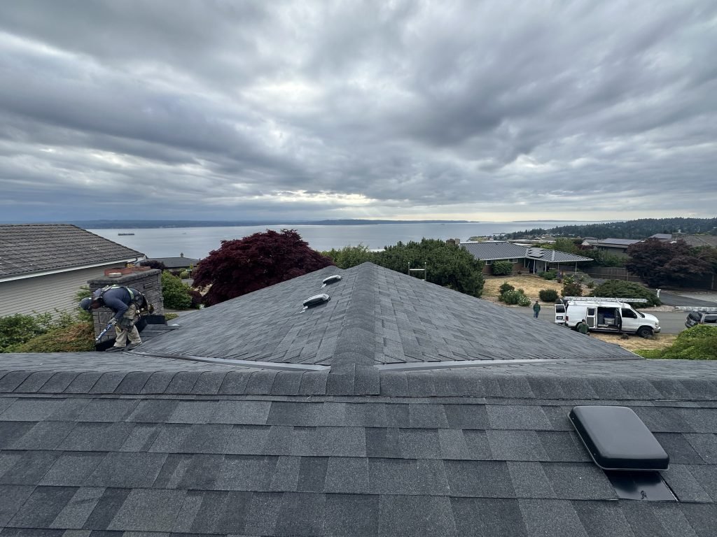 Roof replacement in progress with ocean view and cloudy sky