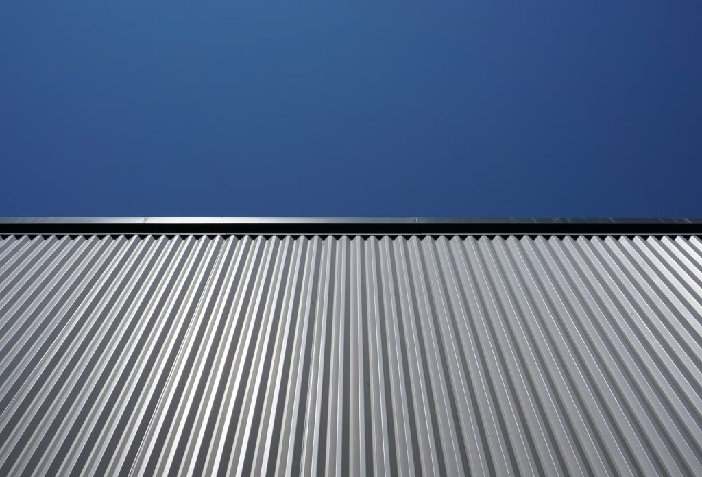 Durable corrugated metal siding under clear blue sky