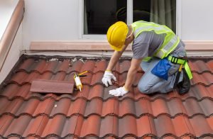 Construction worker is inspecting roof tile cracked