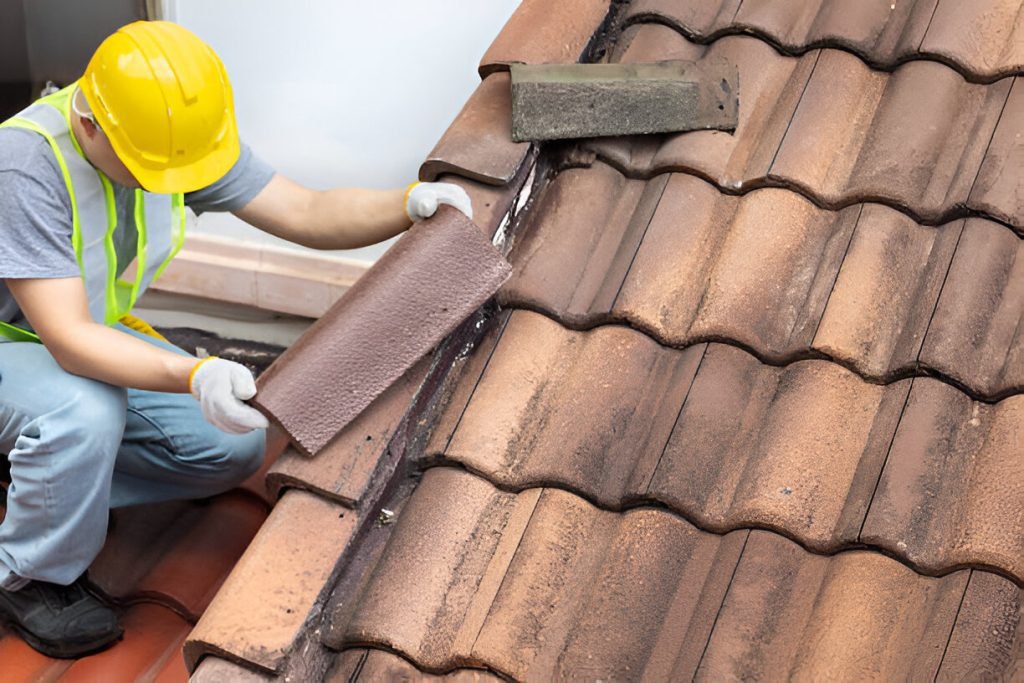 Worker fixing eaves and tiles of the old roof