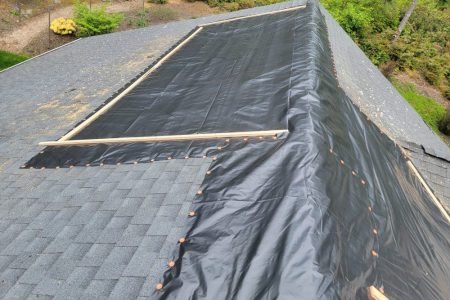 Roof underlayment and tarps secured with nails on residential roof repair