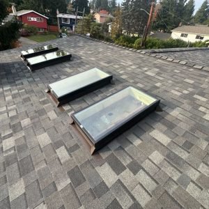 Victorian house with newly installed dark gray shingle roof.