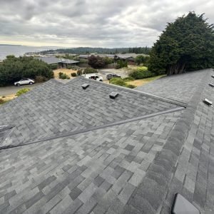 Gray asphalt shingle roof with ridge vents and valley flashing