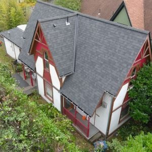 Aerial view of house with new dark gray roof.