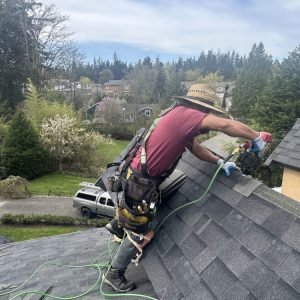 Man wearing safety harness working on roof installation