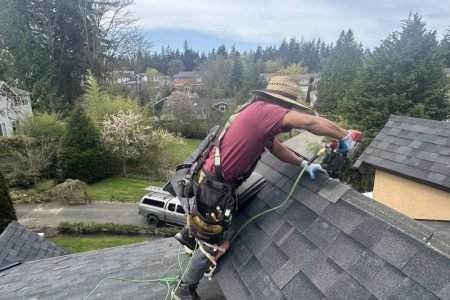 Man wearing safety harness working on roof installation