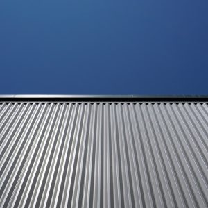 Durable corrugated metal siding under clear blue sky