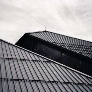 Sleek black metal roofing with modern glass architecture